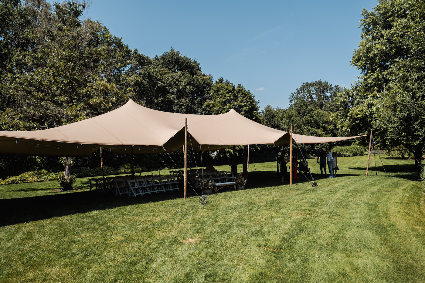 Stretch tent van De Barrier opgezet in het groen aan de vijver voor de huwelijksceremonie van Laura en Jolien