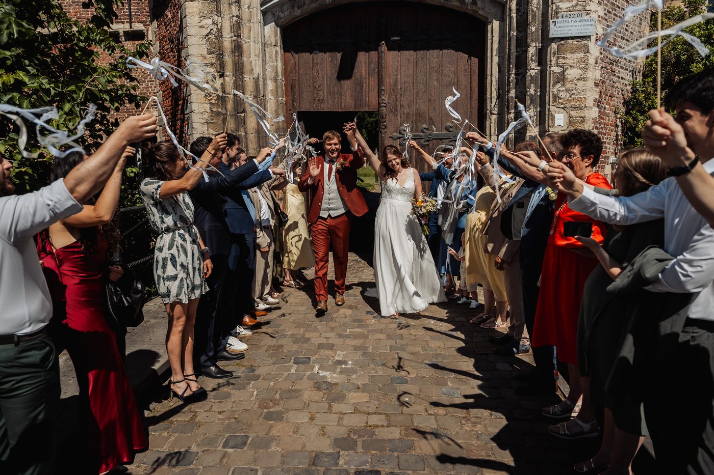 Huwelijksfotografie Leuven &mdash; kasteelexit met lintjessabel en gasten