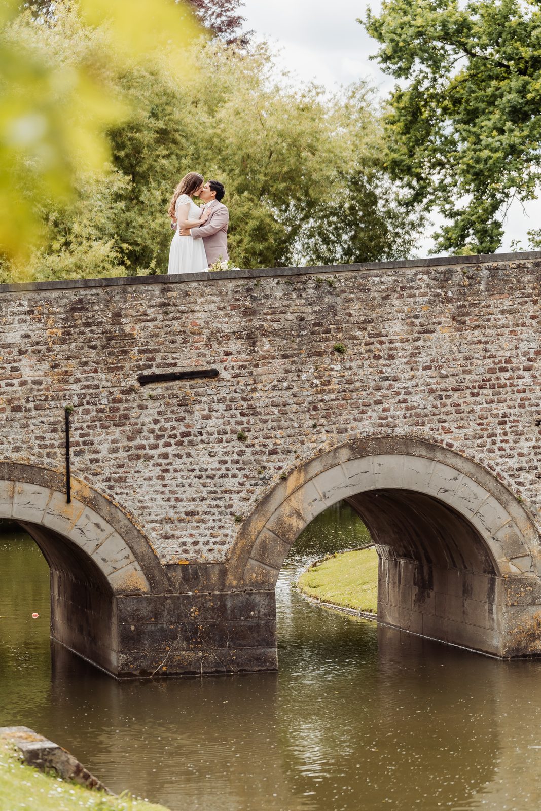 Huwelijksfotografie — koppel kust op stenen brug boven water