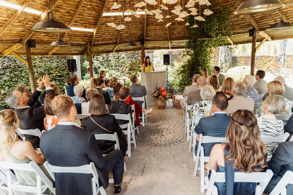 Gasten wonen de huwelijksceremonie bij onder het sfeervolle prieel van Park Ven